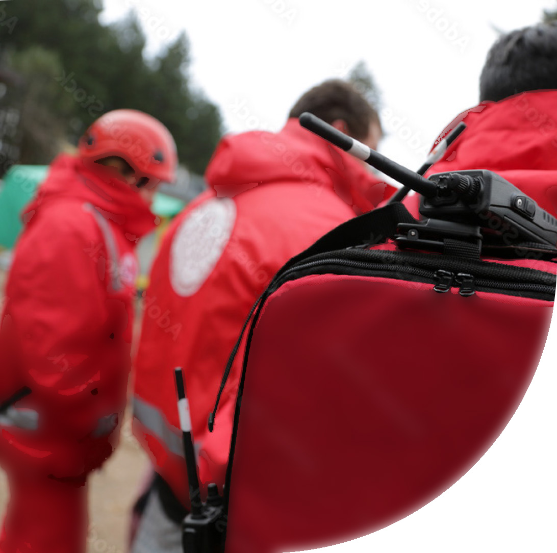 Trois personnes du service d'urgence vêtues de rouge qui marchent et sont visibles de dos